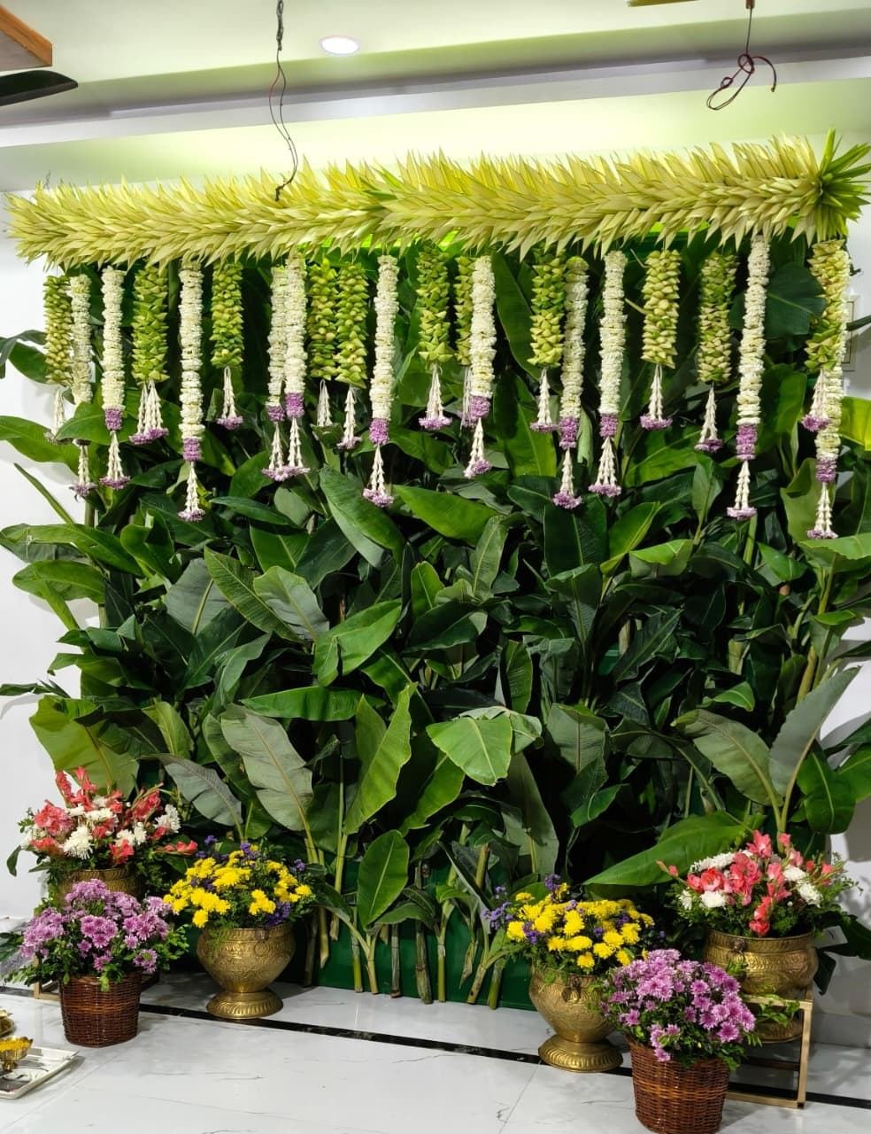 Signature banana leaf wedding mandap backdrop with white garlands by Sri Sai Flower Decorations