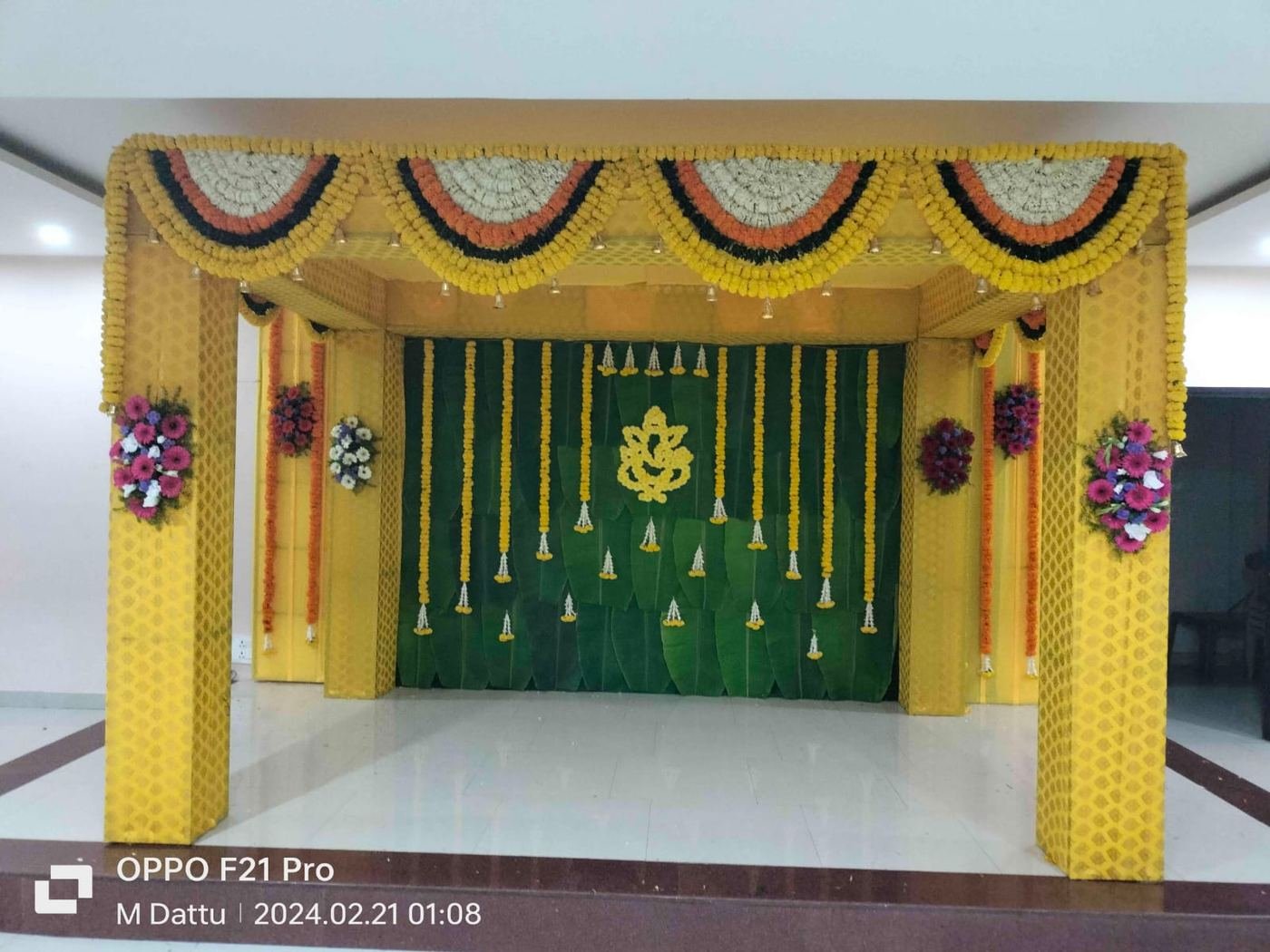 Yellow mandap with marigold swags and banana leaf backdrop