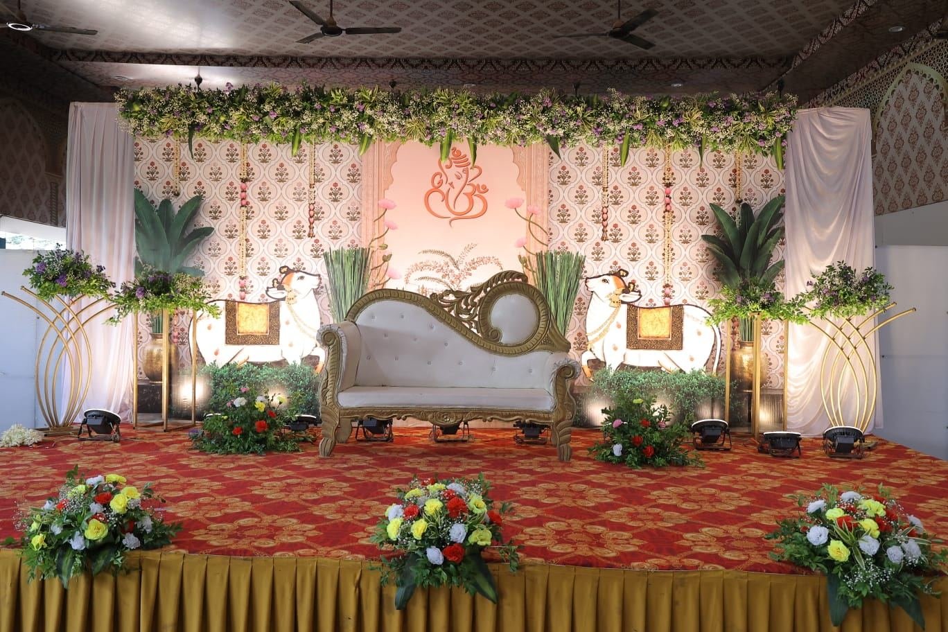 Elegant wedding reception stage with Ganesh motif backdrop